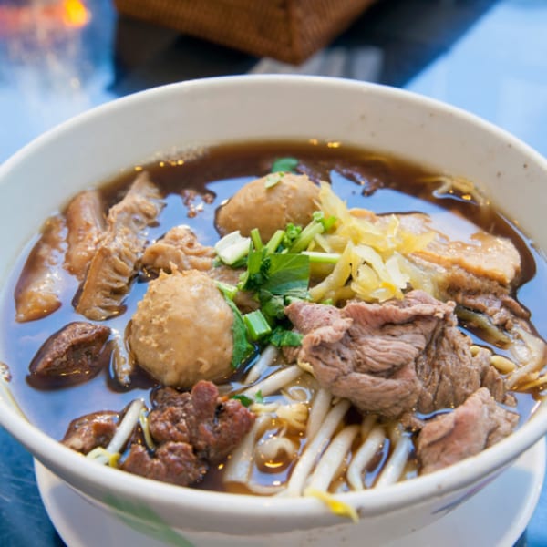 Close-up of a bowl of Pho 9 pho with beef, meatballs, tripe, and bean sprouts.