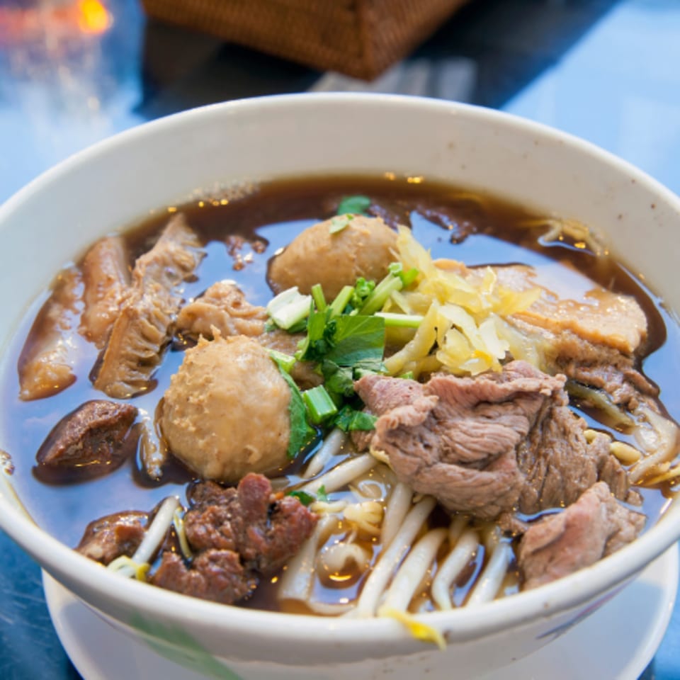 Close-up of a bowl of Pho 9 pho with beef, meatballs, tripe, and bean sprouts.